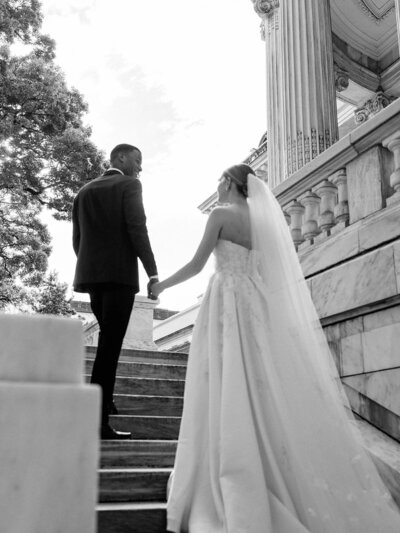 Couple walking up stone stairs to their reception DAR in DC