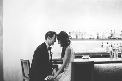 A black and white portrait of a bride and groom sitting in the iconic Pump Room in Chicago