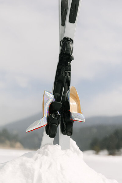 Christian Louboutin wedding shoes styled on skis in the snow at a Colorado winter wedding, photographed by Colorado wedding photographer.
