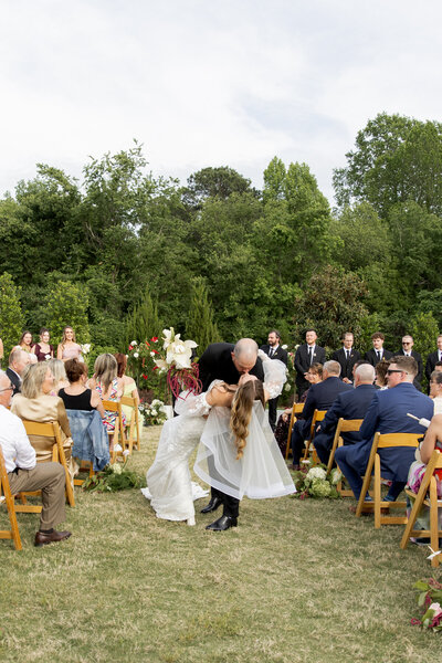 Bride and groom holding hands during Raleigh wedding ceremony, fine-art wedding photography and video by Moments by Hiba.