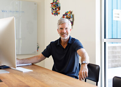 A male consultant dressed business casual looking at the camera in a relaxed manner