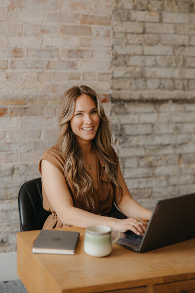 Mother holding baby outside in a field looking happy
