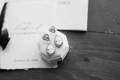 black and white detail image of wedding earrings on a velvet box