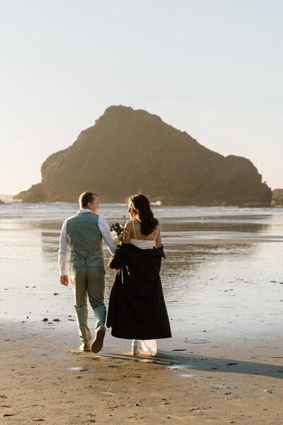 Bride holding up a bouquet of flowers during a beach elopement in Michigan.