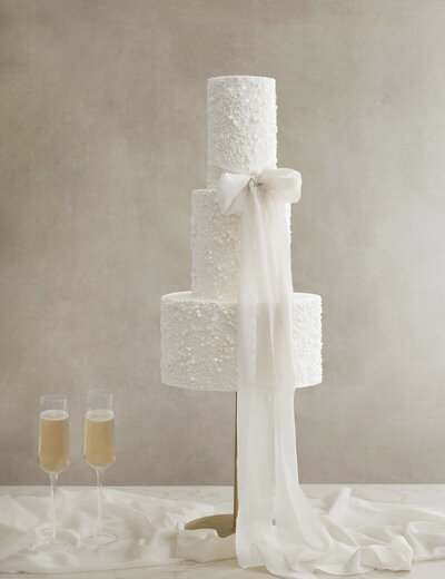 tall three tiered wedding cake with sugar pearls and hand dyed silk bow