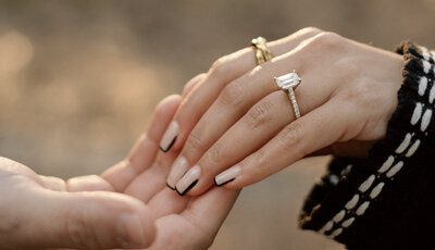 couple holding hands showcasing engagement ring