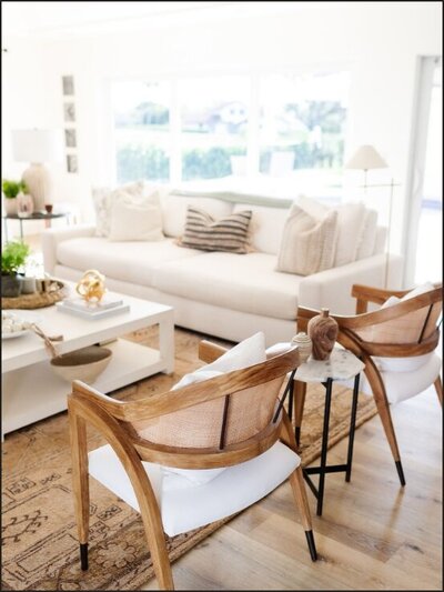 Living room with white couch and wooden chairs