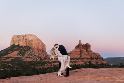 Bride and groom doing a dip kiss on the mountains