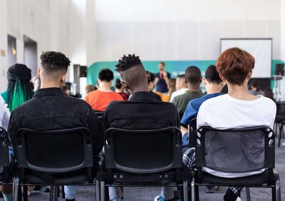 3 teen diverse boys sitting school facing away