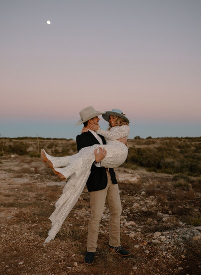 Bride and Groom walk alongside shoreline
