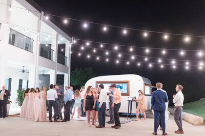 Guests eat at a dessert truck during a reception.