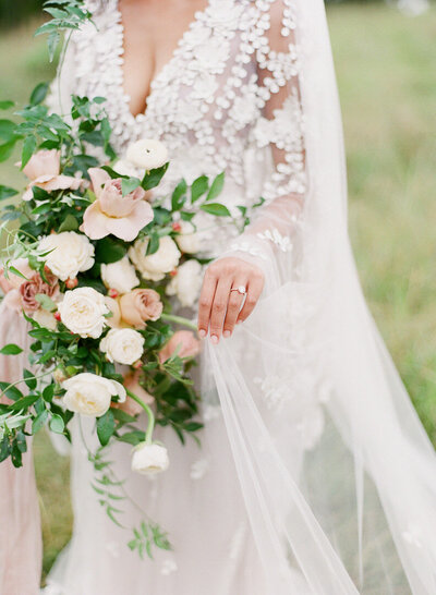 Bride Delicately Holding her veil by her Bouquet of Flowers Photo