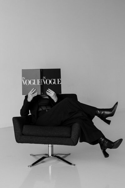 philly wedding photographer sitting in a chair and holding a vogue magazine