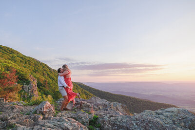 couple stands on the rocks of the blue ridge mountains together