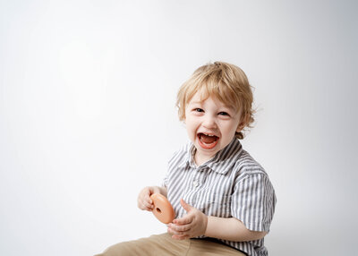 a toddler boy playing with wooden toys for his birthday portraits in rio, wi