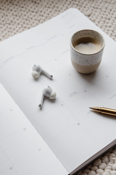 Coffee cup, pen, and brand strategy worksheet flatlay on neutral workspace