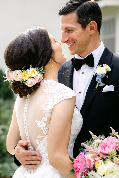 bride and groom smiling romantically at one another