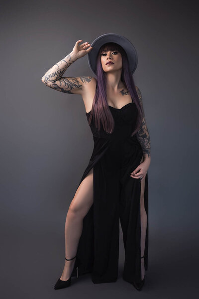 A woman poses with a had and a glamourus gown for a boudoir photography photoshoot in Vancouver