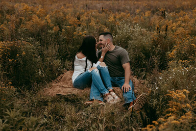 Couple sitting in a field about to kiss