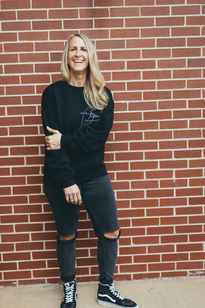 Kim smiling in a black sweatshirt