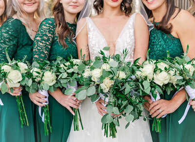 bride and bridesmaids in green with bouquets