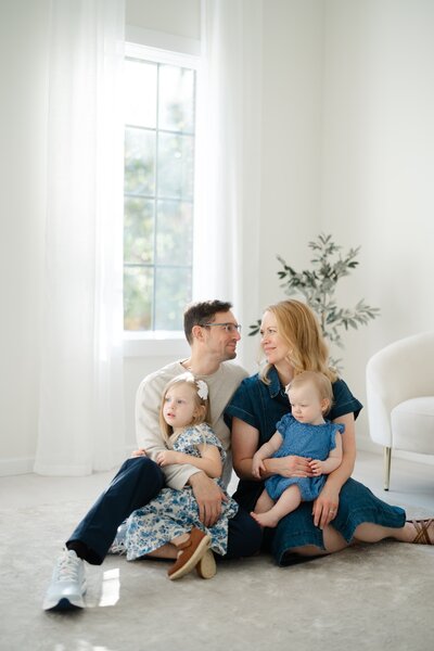 a-family-of-four-is-sitting-on-the-floor-at-studio-ivoire-in-franklin-tn-with-dolly-delong-photography