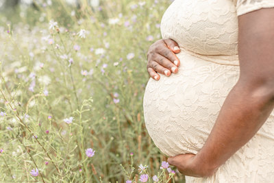 Close up of pregnant woman's baby bump for maternity photo shoot out in nature