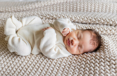 newborn baby sleeping on bed during photos