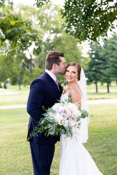 Groom kissing bride on the head at Stones River Country Club wedding, Tennessee