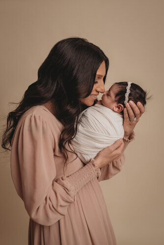 Atlanta, Georgia newborn photos at newborn photography studio with mom looking at baby smiling and touching noses.