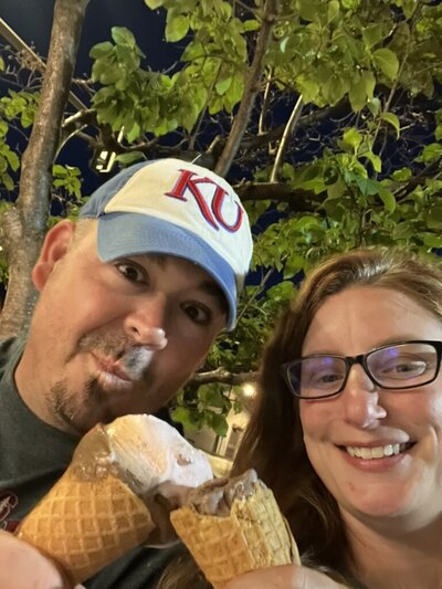 Megan and her husband smiling while sharing ice cream outdoors | Senior Photographer in Lawrence, KS
