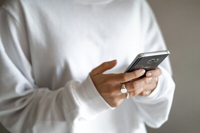 Stock photo of hands holding a phone, symbolizing scheduling a consultation for hormone therapy at Wellness & Hormone Health, based in Centennial, Colorado.