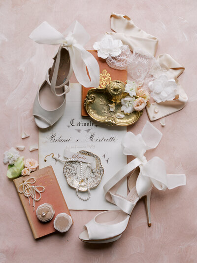 bridal shoes on flat lay with marriage certificate, ring, and details
