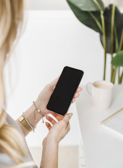 women holds phone with plants in background, illustrating services link