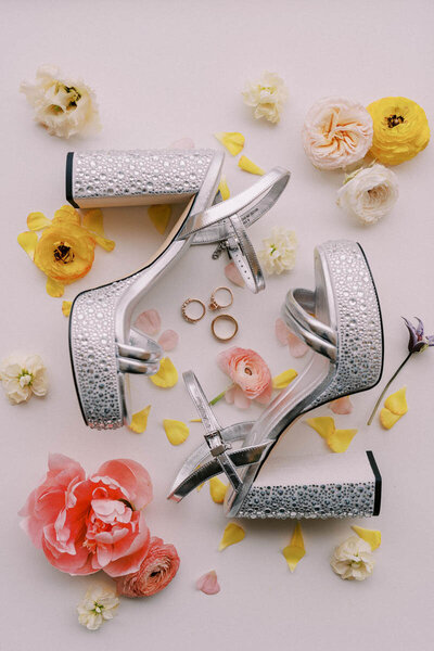 Sparkling bridal shoes with wedding rings and pastel flowers styled for detail shot by Toronto wedding photographer