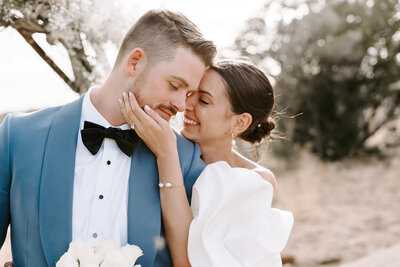 groom in blue suit holding bride