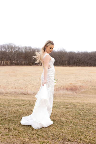 bride wearing bridal gown while standing in a field