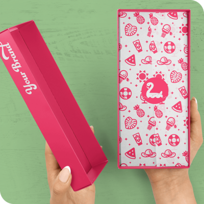 A pink box with a logo printed on the side of the lid. Inside the box is custom, branded tissue paper