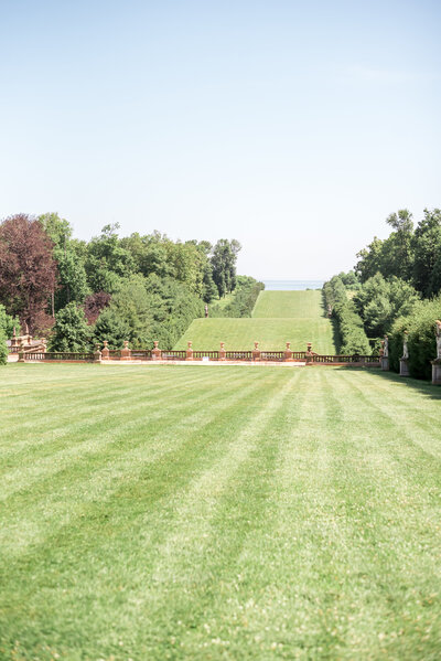 The expansive, ocean-facing lawn at Castle Hill on the Crane Estate, framed by trees and leading down to the Atlantic — an iconic ceremony backdrop for timeless New England weddings.