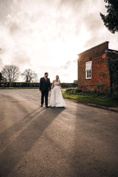 Bride & Groom holding hands outside wedding venue