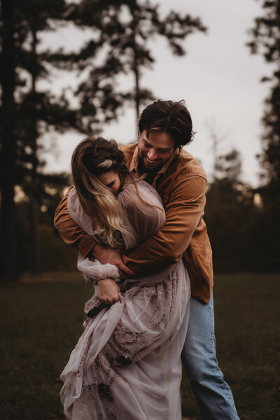 Husband and wife hugging each other playfully during couples photo shoot in houston.