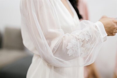 A close up of the sleeve of a lace wedding dress