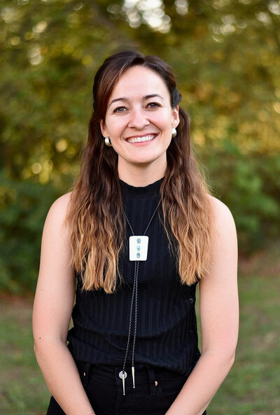 Brunette girl kisses a sorrel horse's muzzle