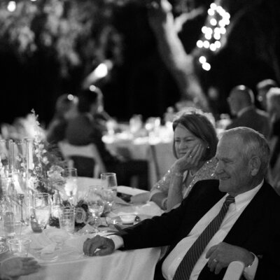 Black and white photo of parents sitting at a reception table