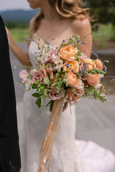 bride holding pink and orange bridal bouquet in vermont