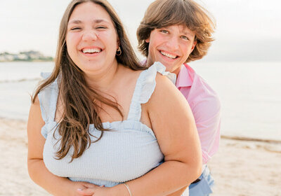 Teenage siblings hugging and smiling on Cape Cod beach