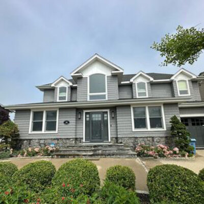 Exterior of a grey house with well-maintained landscaping
