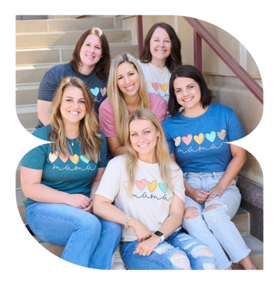 a team of mamas sitting on steps with arms in lap wearing mamas shirts