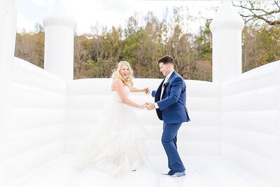 Bride and groom jumping in a white bounce house | Alabama wedding photographer Amanda Horne