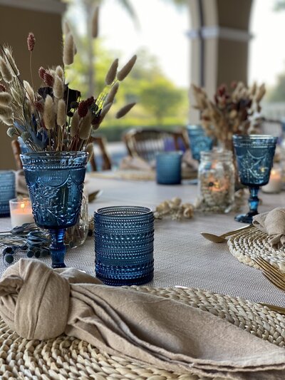 Table setting with blue glasses and a boho chic design